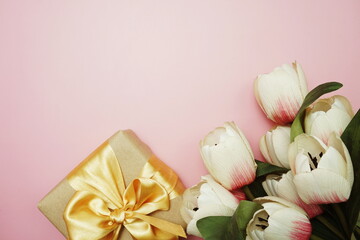 Gift box present and tulip flower bouquet on pink background