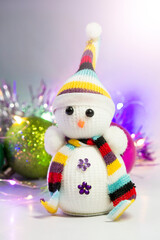 Knitted snowman on the background of Christmas toys