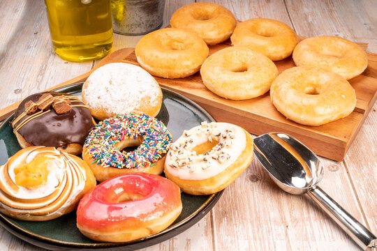 Mixed donuts, original flavor, chocolate, marmalade and fancy toppings on wooden background.