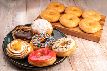 Mixed donuts, original flavor, chocolate, marmalade and fancy toppings on wooden background.