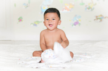 Cute baby boy sitting on fluffy carpet at home. Infant is 8 months. - People, Health care concept. Soft focus, Selective focus.
