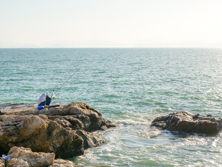 Angler on the reef by the sea