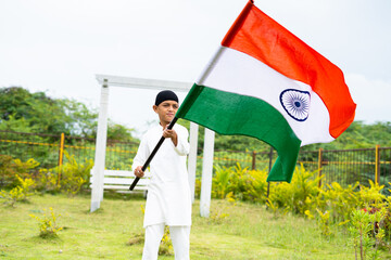 Young muslim Kid waving Indian flag at park - concept of patriotism, nationalism, Indian...
