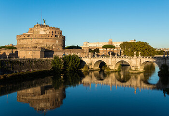 Mesmerizing view of Castle Sant'Angelo reflecting on the water against a blue sky in Rome, Italy