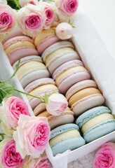 Colorful macaroons in a gift box and roses