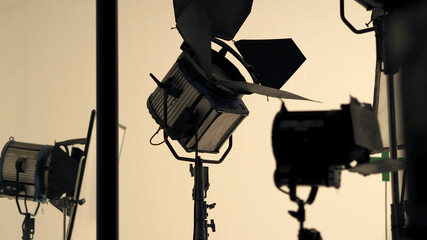 Big studio flashlight on a tripod and softbox paper in large size studio for video or film...