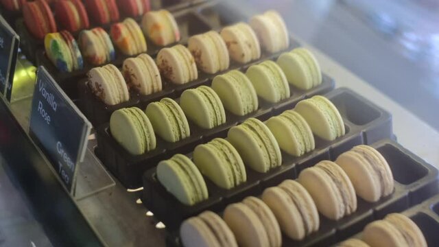 Arrangement of sweet macaroons desserts assortment in cafe window showcase, delicious french patisserie