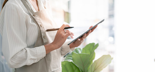 Closeup businesswoman hands using portable tablet with stylus pen, copy space.