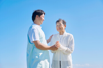 介護士と高齢者　屋外