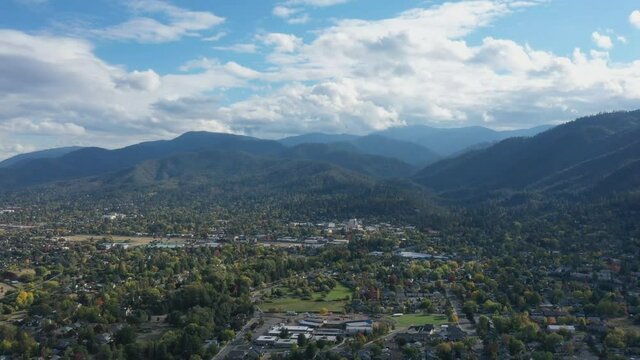 Beautiful view of the place Ashland in a slow motion cinematic shot of the natural background of the high mountains above the houses and trees on the land. Aerial view