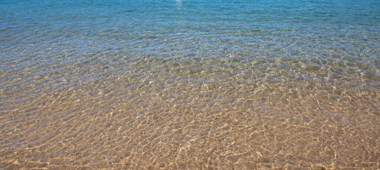 Sea background, nature of tropical summer beach with rays of sun light. Sand beach, sea water with copy space, summer vacation concept.