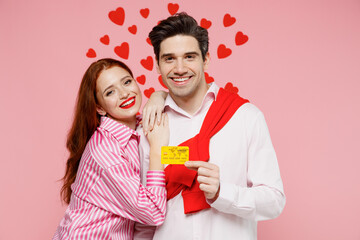 Young smiling fun couple two friends woman man in casual shirt hold in hand credit bank card...