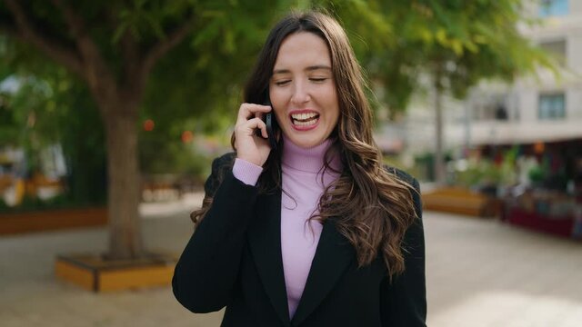 Young hispanic woman smiling confident talking on the smartphone at park