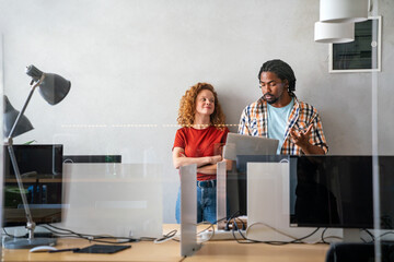 Happy smiling business colleagues working together online on a tablet in office