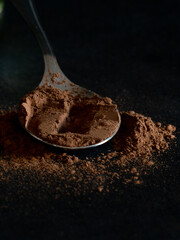 close-up pieces of chocolate with cocoa powder on dark background