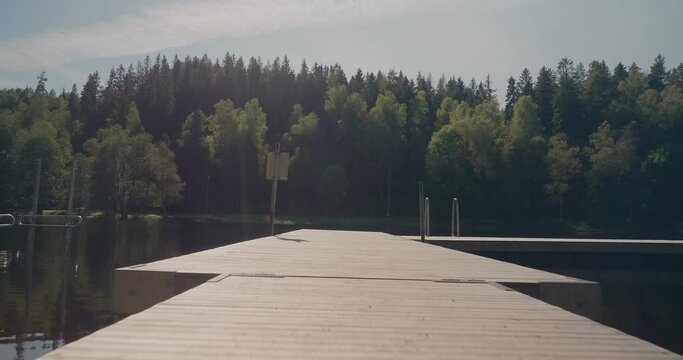 Entering Wooden Jetty and Watching The View of Kypesj&ouml;n Lake, Sunny, Bor&aring;s Sweden - Wide Shot Tracking Forward and Turning Left