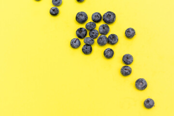 Tasty ripe blueberries on yellow background, flat lay