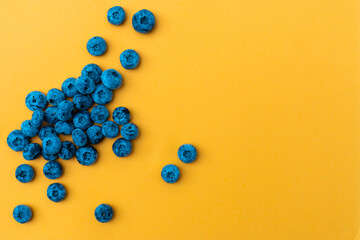 Tasty ripe blueberries on yellow background, flat lay