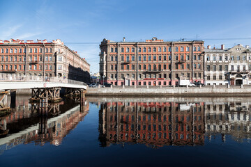 View of the Fontanka River embankment with old buildings, Gorstkin Bridge and their reflection in the water. Saint Petersburg, Russia
