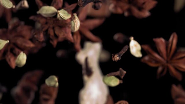 Super Slow Motion Shot of Flying Tea Mix Spices in Black Background.