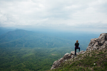 Fototapeta premium woman traveler looks at the beautiful landscape from the top of the mountain