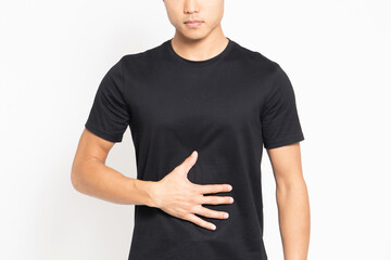 白い背景の前に立って、お腹に手を当てる黒いTシャツを着ている男性
