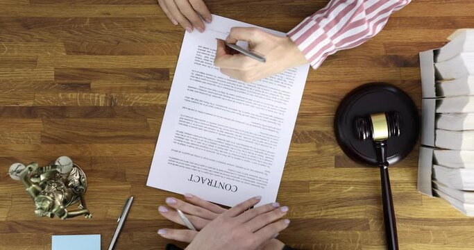 Judge giving document with contract to woman to sign in courthouse top view 4k movie