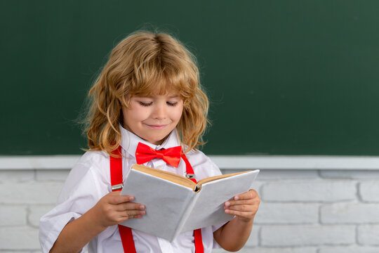 School boy reads a book in the classroom. Back to school, first day at school.
