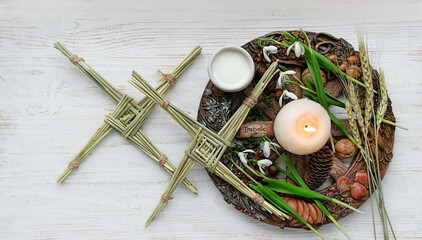 Wiccan altar for Imbolc sabbath. winter and spring pagan holiday ritual. Brigid's cross, milk,...