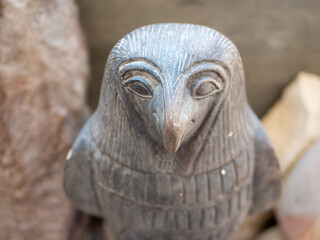 Close-up of a stone statuette of the Egyptian deity Horus with a bird's head. Selective focus. Luxor, Egypt.