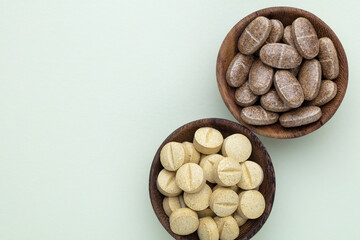 Alternative medicine tablets on a wooden spoon.