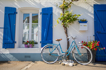 Fototapeta na wymiar Vieux vélo bleu dans les rues d'un village en Vendée.