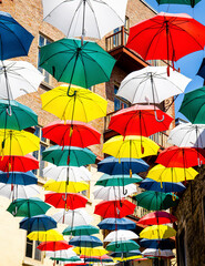 Obraz premium colourful umbrellas hanging over the street