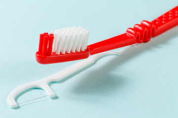 Close-up toothbrush and flossing toothpick on the blue background