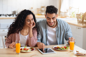 Young Middle Eastern Couple Shopping Online On Digital Tablet While Having Breakfast