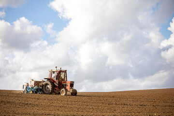 Obraz premium Agriculture en France, vieux tracteur labourant son champ au printemps.
