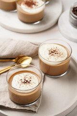 Italian chocolate and coffee mousse dessert semifreddo - half-frozen ice cream with whipped cream and cocoa powder in small glasses