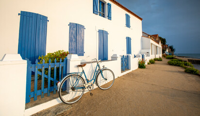 Vieux vélo bleu en bord de mer, le long d'une villa sur l'île de Noirmoutier en Vendée, France.