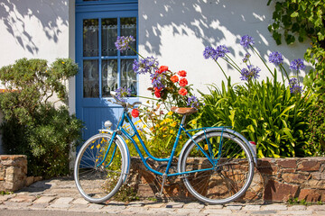Fototapeta na wymiar Vieux vélo bleu dans les rues d'un petit village en Vendée, France.