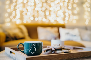 christmas gingerbread and cookies on the table on the background of a light bulb and cocoa with marshmallows
