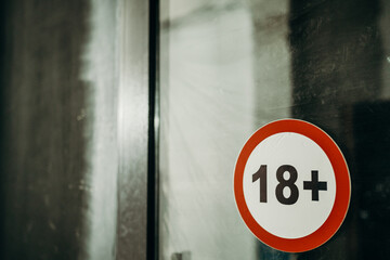 sticker 18+ on the dark door