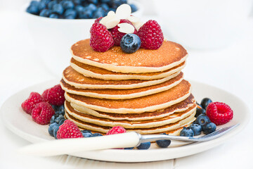Classic American pancakes with fruit on a light background.