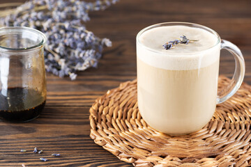 Homemade raf coffee with lavender syrup and coconut milk in a mug on a wooden table. Russian drink.