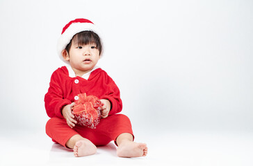 Baby wearing christmas santa costume holding gift box isolated on white background