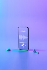 Music background. Mobile smartphone screen with music application, sound headphones. Audio voice with radio beats on neon gradient. Recording studio or podcasting banner with copy space.
