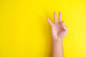 Naklejka premium close up hand on yellow background