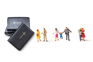 bible with miniature people isolate on white background.