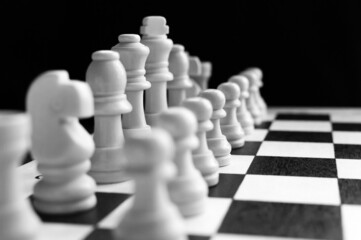 Chess pieces on wood board.Chess game. Set of chess pieces on the board. strategy games. Games for the development of intelligence. Blurred. Back-and-white.
