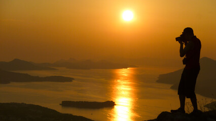 Silhouette eines Fotografen vor einer Insel Landschaft in der untergehenden Sonne