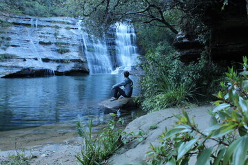 homem admirando Cachoeira do lago Azul em Jaguariaíva, Paraná, Brasil